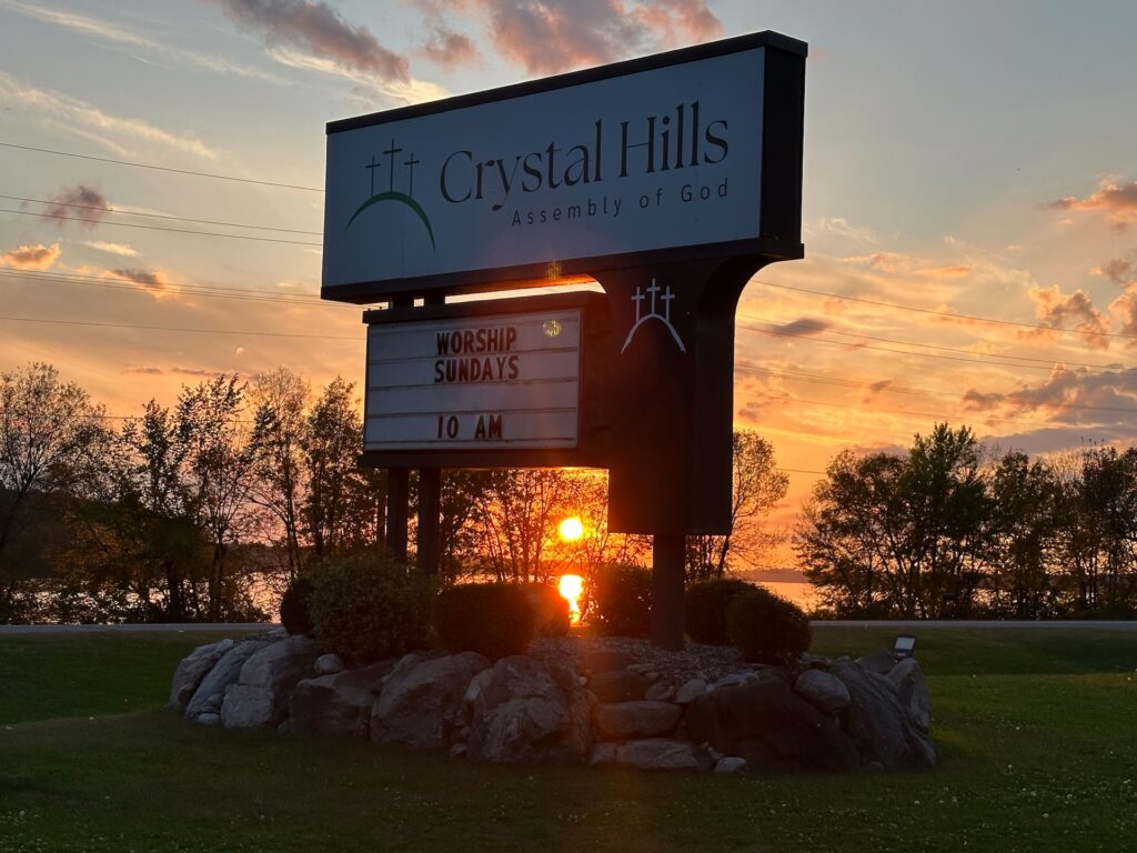 a group of people entering the church while a greeter hand them a piece of paper